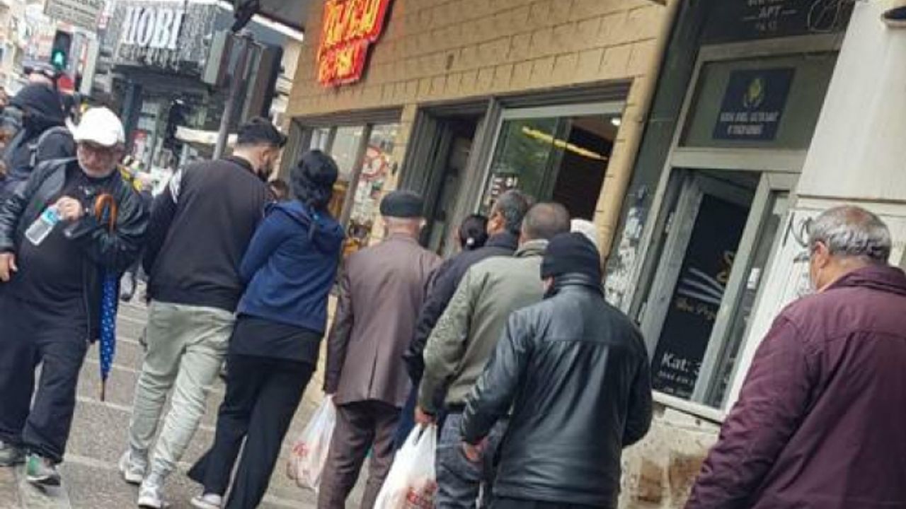 Buca'da yağmur altında askıda ekmek kuyruğu